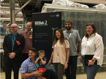 seven people surrounding pop-up banner